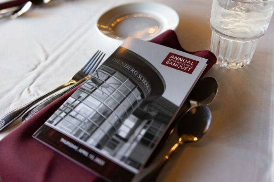 Image of the annual accounting banquet program atop a table setting