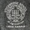 Closeup of Stockbridge seal embroidered in white on gray fleece material